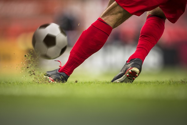 athlete kicking a soccer ball