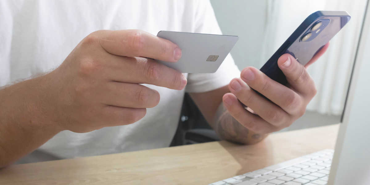 Client saisissant les renseignements d’une carte de crédit sur un téléphone intelligent pour effectuer un achat en ligne.