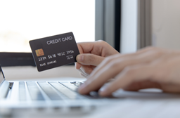 Une personne tenant un téléphone portable et une carte de crédit à la main. 